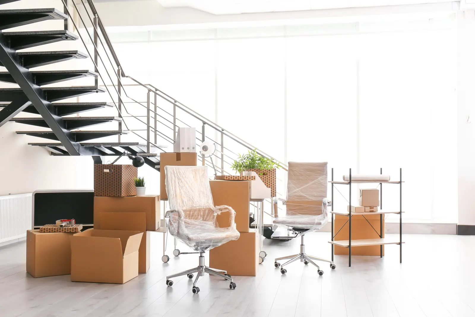 Büromöbel und Umzugskartons in einem leeren Büro